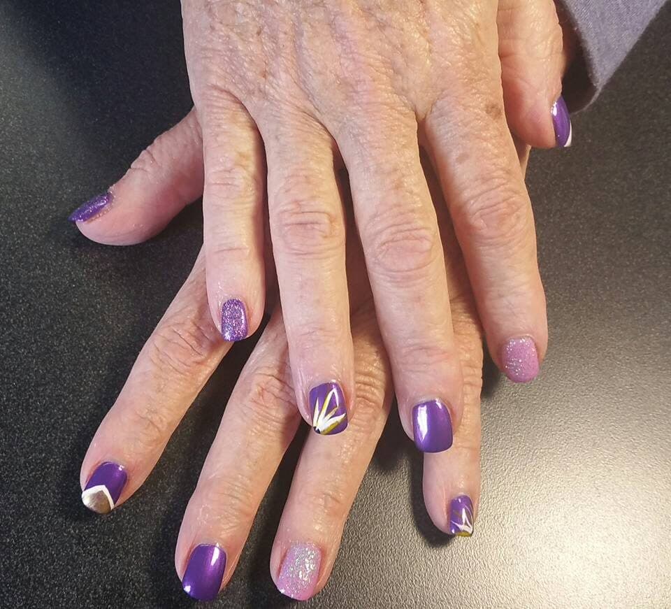 Purple and white nail art with glitter detail
