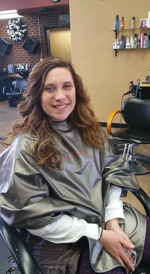 Smiling client in a styling cape at Bombshell Salon